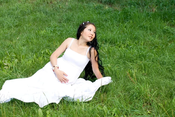 Çimlerde oturan güzel hamile kız — Stok fotoğraf