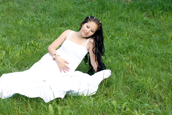 美丽的怀孕女孩坐在草地上 — 图库照片