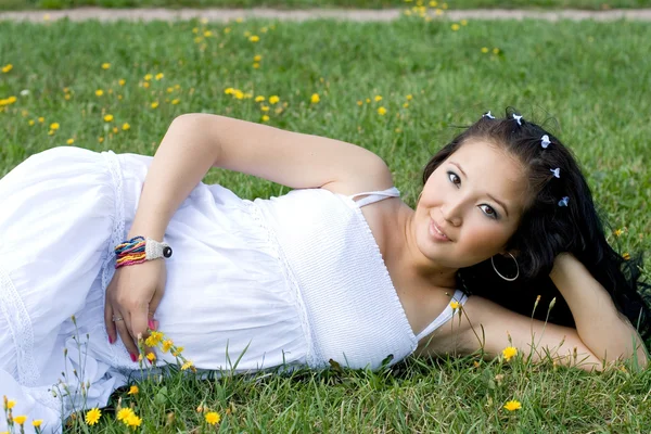 Vackra gravid flicka liggande på gräs — Stockfoto