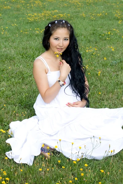Krásná těhotná dívka sedící na trávě — Stock fotografie