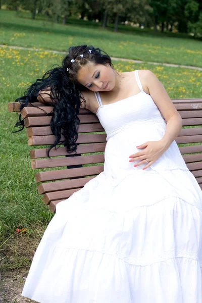 Schöne schwangere Mädchen zu Fuß in Park — Stockfoto