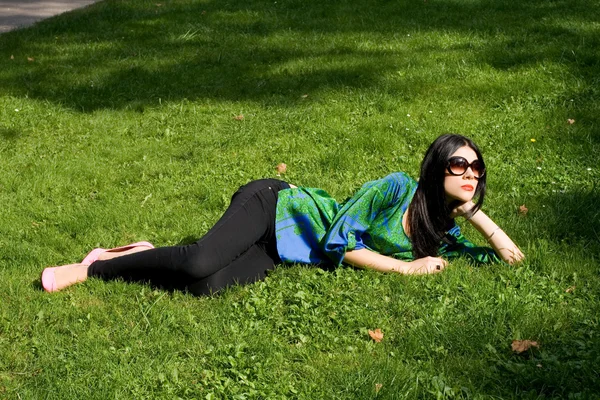 Κορίτσι ξαπλωμένη στο γρασίδι στο πάρκο — Φωτογραφία Αρχείου