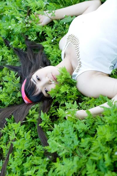 Retrato de close-up de uma linda menina deitada entre as flores — Fotografia de Stock