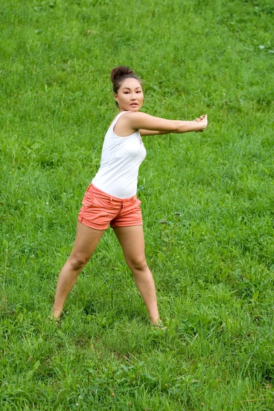 Девушка делает упражнения в парке — стоковое фото