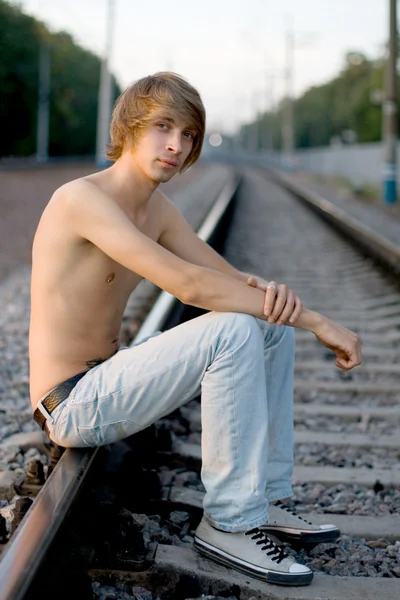 英俊的男人走在铁轨附近 — 图库照片