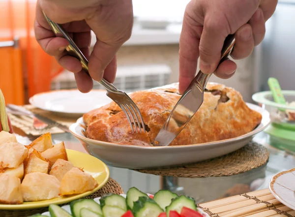 stock image Man cut meat pie