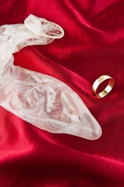 Gold wedding ring and condom clipart