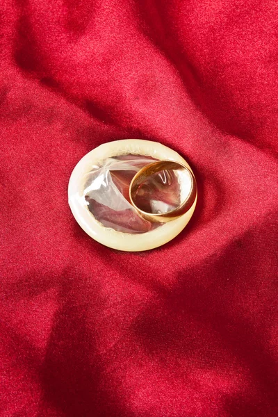Золотое свадебное кольцо и презерватив — стоковое фото