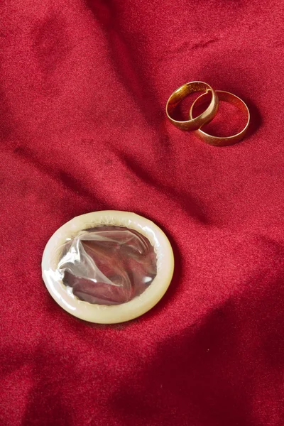 Золоті обручки і презервативи — стокове фото