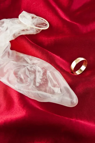 Zlatý snubní prsten a kondom — Stock fotografie