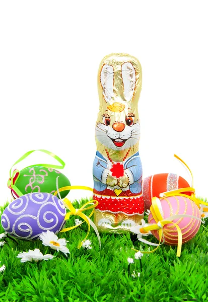 Chocolate easter bunny and colorful eggs on grass — Stock Photo, Image