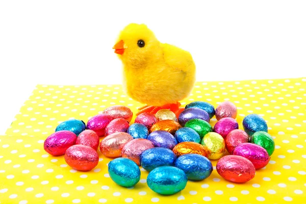 Juguete de pollo y coloridos huevos de Pascua en la servilleta —  Fotos de Stock