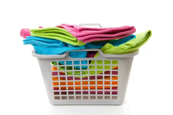 Cesta de lavanderia cheia de toalhas coloridas — Fotografia de Stock