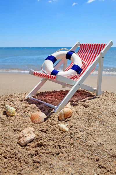 Sedia da spiaggia vicino all'oceano con conchiglie — Foto Stock