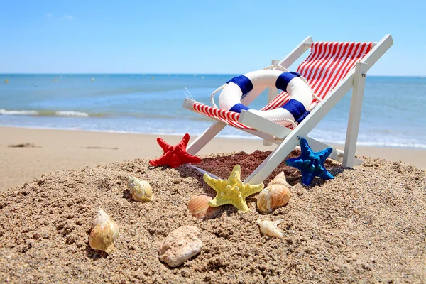 Sedia da spiaggia vicino all'oceano con conchiglie — Foto Stock
