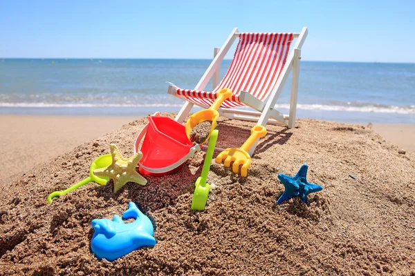 Beach chair near the ocean with toys — Stock Photo, Image