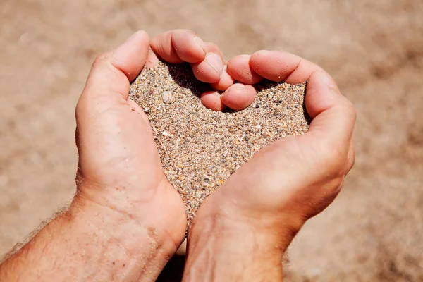 Händerna fylld med sand — Stockfoto