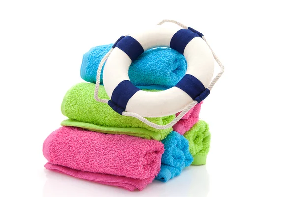 Zomer versnelling; kleurrijke handdoeken en leven buoy — Stockfoto