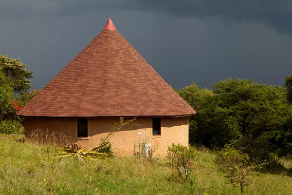 Typiska afrikanska byggnaden mot mörka hotande himlen — Stockfoto