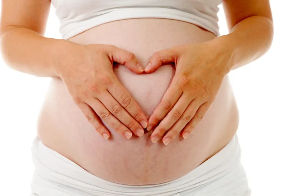 Vientre embarazada con las manos en forma de corazones — Foto de Stock