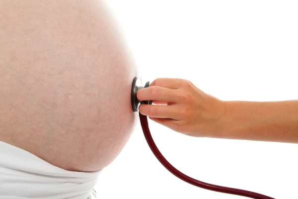 Childs hand with stethoscope on pregnant belly — Stock Photo, Image