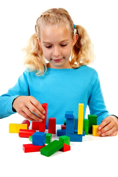 Giovane ragazza bionda sta giocando con blocchi di legno colorati — Foto Stock