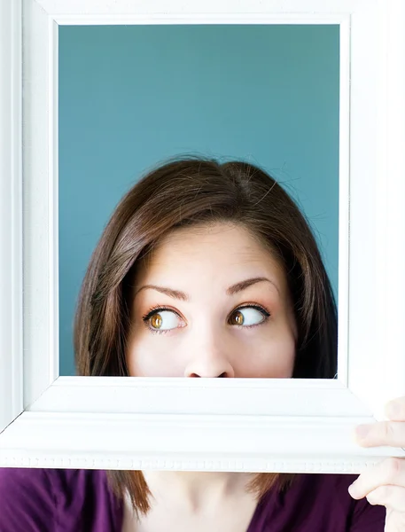 Silly woman peeking out from a vintage picture frame — Stock Photo, Image