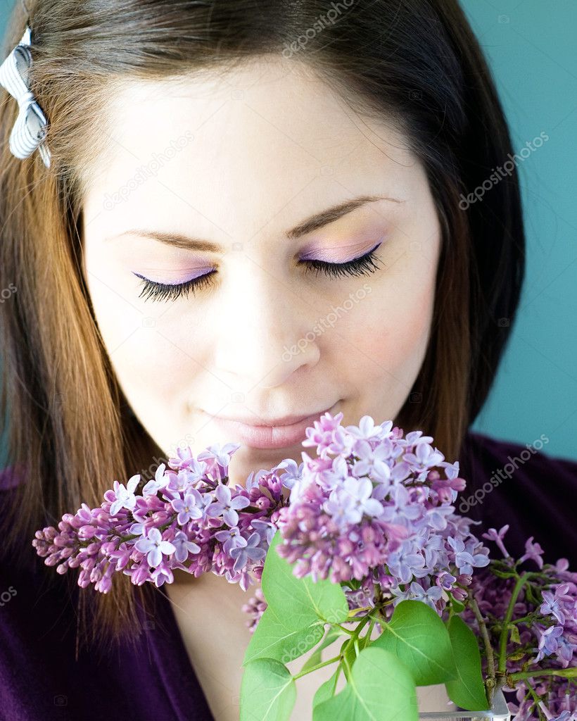 Young woman smelling lilacs