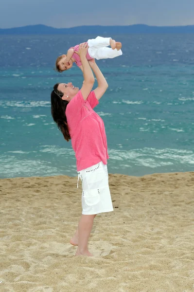 Moeder met haar baby op strand — Stockfoto