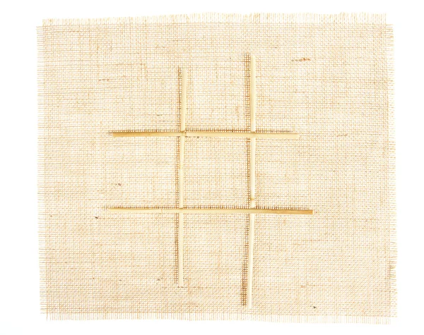 Sackcloth with Tic Tac Toe game pattern with straws on burlap — Stock Photo, Image