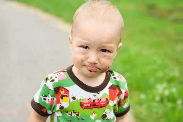 Kind met vuile grappig gezicht buiten op speelplaats. — Stockfoto
