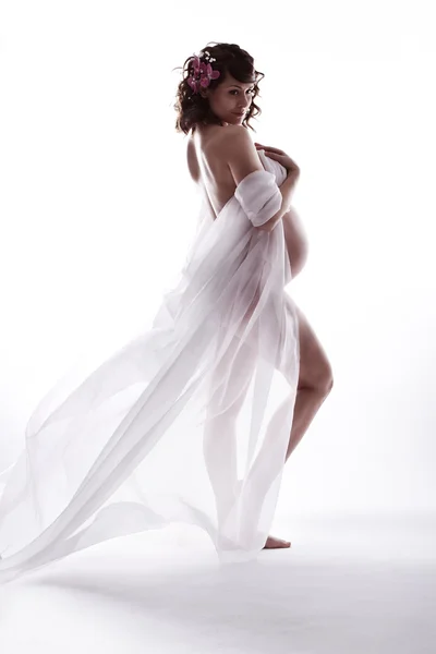 Zwangere vrouw in Wit zwaaien vliegende jurk. kijkt uit over shoul — Stockfoto