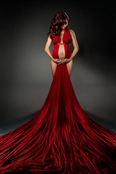 Sexy kobieta w czerwonej sukience macha, patrząc w dół. — Zdjęcie stockowe