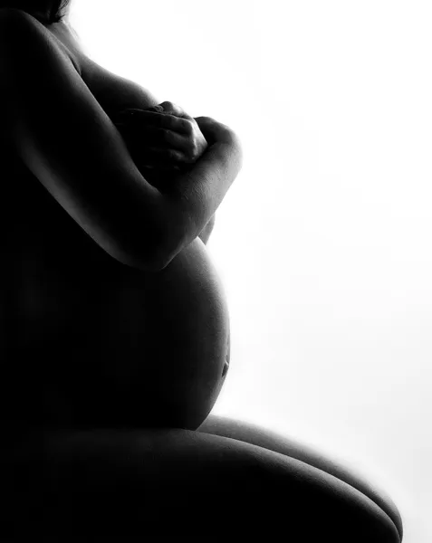 Silhouette della donna incinta. Cura del corpo. Vista laterale. Sopra bianco . — Foto Stock