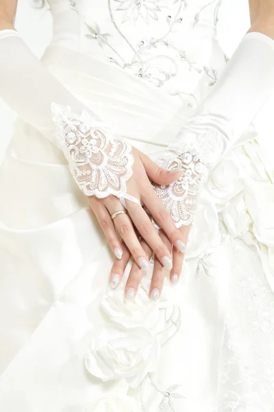 Bride's hands with manicure in white lace gloves — Stock Photo, Image
