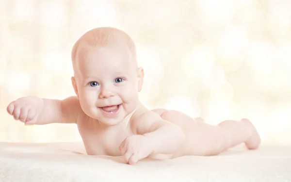 흰색 배경 위에 누워 웃는 귀여운 아기 — 스톡 사진