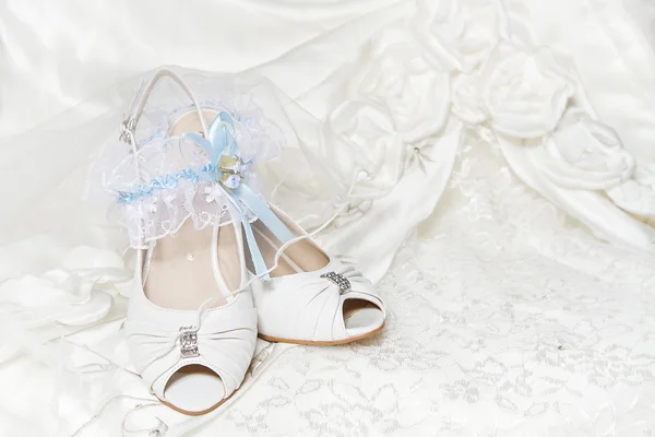 Подвязка для обуви невесты, с голубой лентой, свадебное платье. Крупный план — стоковое фото