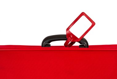 Red suitcase with blank identification tag over white. Closeup. clipart