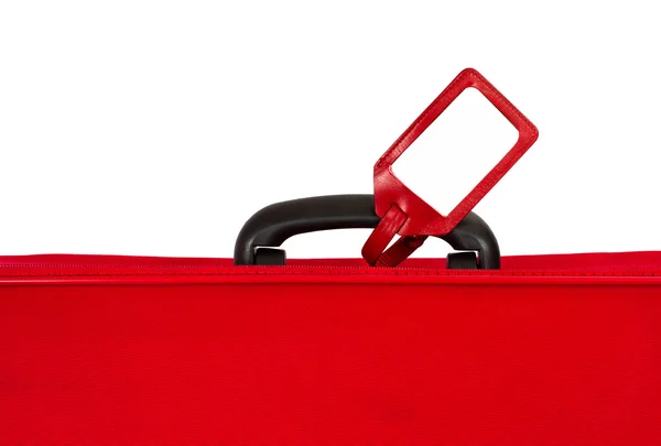 Red suitcase with blank identification tag over white. Closeup. — Stock Photo, Image