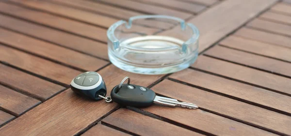 Car keys with remote control and ashtray — Stock Photo, Image