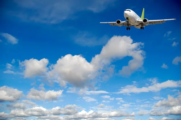 Viagens aéreas - Avião voando no céu azul com nuvens — Fotografia de Stock