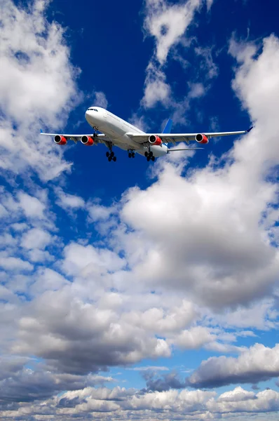 Letecké dopravě - letadlo letí v modrou oblohu s mraky — Stock fotografie