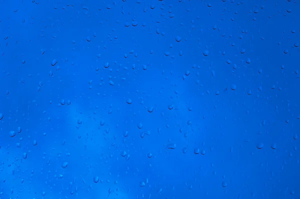 Blå vatten droppar på fönster — Stockfoto