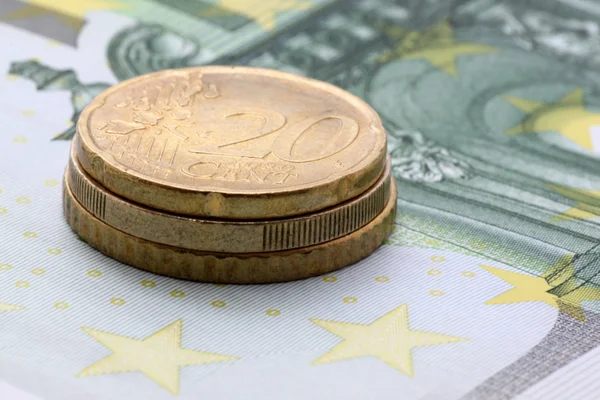 Monedas en euros en billetes de cien euros — Foto de Stock