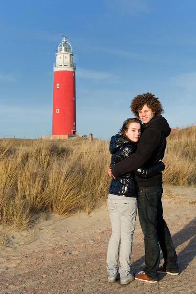 Couple in love near red lighthouse — Stock Photo, Image