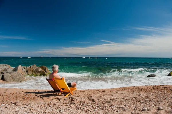 Пожилой человек на пляже — стоковое фото