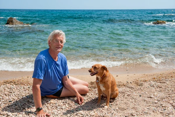 Uomo con il suo cane in spiaggia — Foto Stock