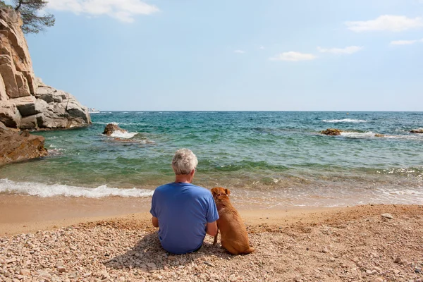 Homme avec son chien à la plage — Photo