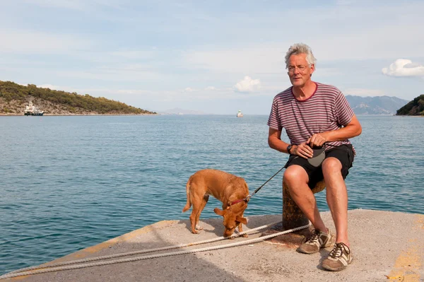 Человек с собакой в гавани — стоковое фото
