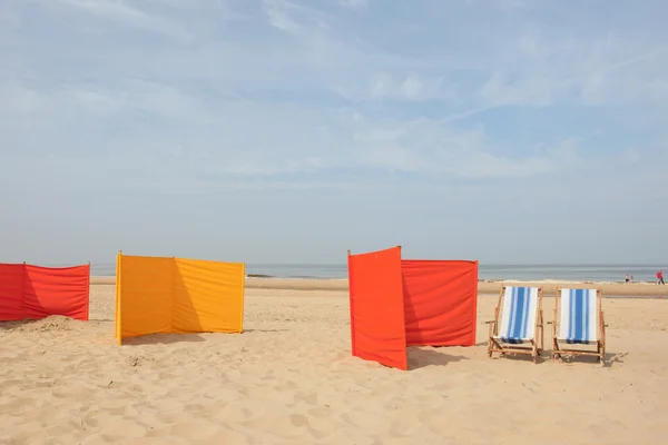Orange und gelbe Windschutzscheiben am Strand — Stockfoto